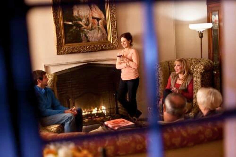 A group of friends enjoys an intimate gathering by a fireplace.