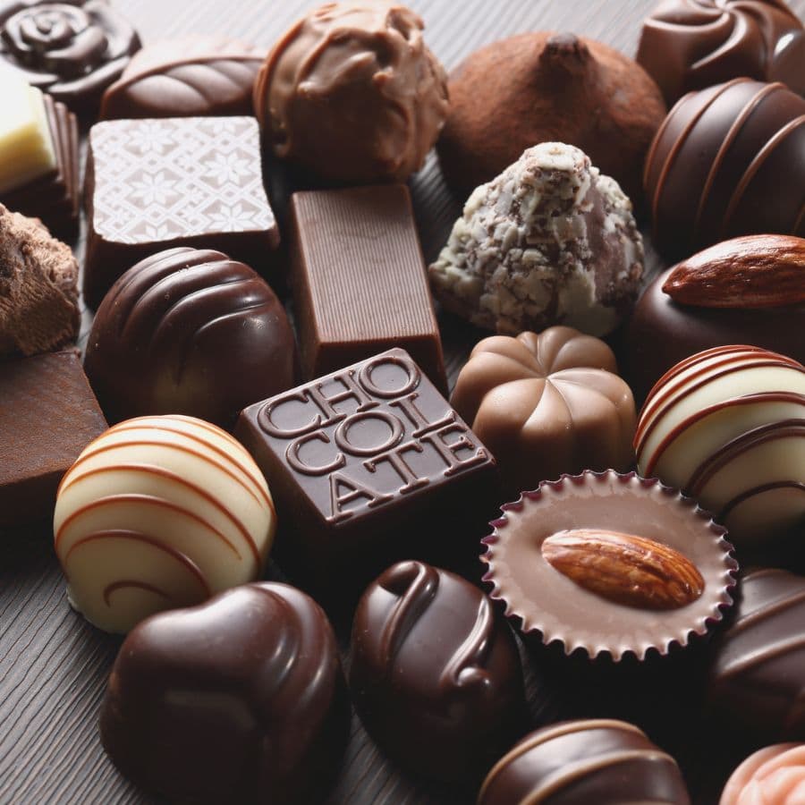 An assortment of various chocolates including truffles, bars, and pralines.